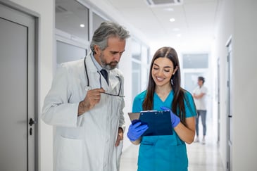 A doctor and medical sales rep review paperwork